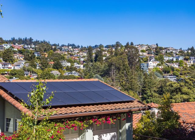 A house with solar panels on its roof under a clear sky